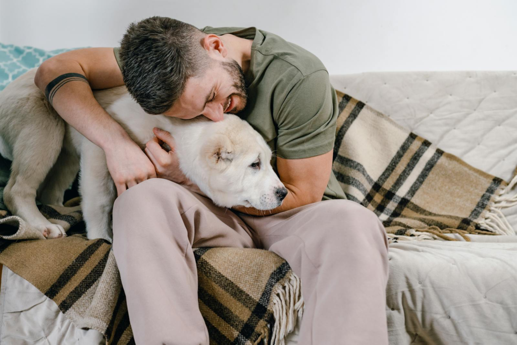 Happy man with dog at home, envisioning sustainable allergy treatment